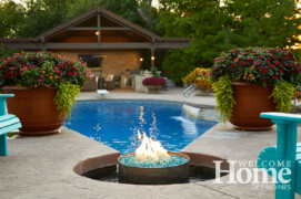 Curves and circles give the feel of undulating waves in an Urbandale yard. Photo by Jack Coyier, courtesy of Ted Lare Design + Build. Fire pit and large urns with flowers by the pool's edge