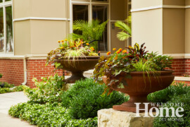 Large round urns filled with annuals add interest to the linear front of the home.