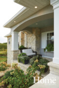 Limestone paired with white offers a lovely combination to the classic home, complete with Southern touches. Large boxes hold greenery.