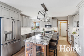Contrasting wood on the island and new wood floors set off the soft gray wall cabinets and new granite countertops.