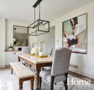 Mixed textures and soft neutrals continue in the dining room, from the iron light fixture to the fabric-covered chairs alongside the dining table.