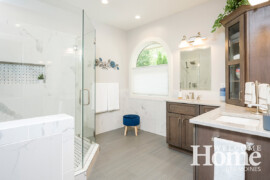 Luxurious materials and deep blue accents create a spa-like master bath.