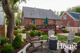 This view of the backyard shows the raised deck and the welcoming fire pit.
