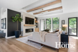 The living room details include a floor-to-ceiling fireplace and two beams in the ceiling.