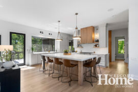 The great room showcases the living room, dining area, and kitchen while huge windows soak in the views.