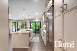 Light cabinetry contrasts with the wide-plank floors and black trim on the windows.
